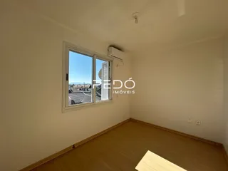 Interior de um cômodo com piso de madeira e janela.