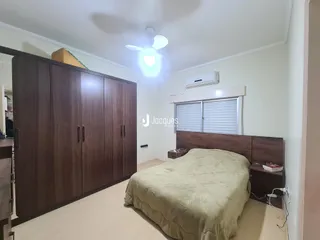 Quarto com armários de madeira e cama em um imóvel no Brasil.