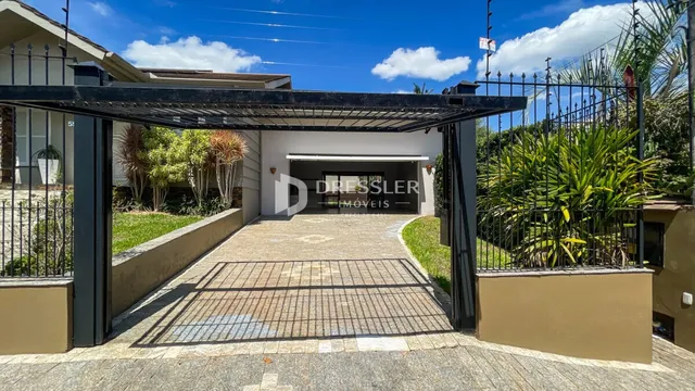 Fachada da entrada de uma propriedade em Lajeado, Brasil, com portão e calçada.