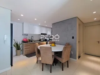 Uma sala de jantar com mesa e cadeiras de madeira clara.