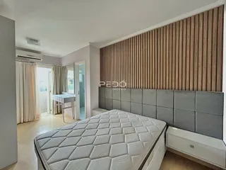 Quarto com cama grande e parede texturizada.