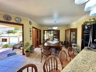 Interior de uma sala de jantar com piso de cerâmica e portas de madeira.