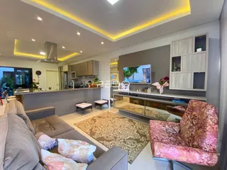 Sala de estar moderna com cozinha integrada e decoração contemporânea.