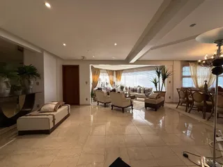 Sala de estar ampla com piso de cerâmica e grandes janelas.