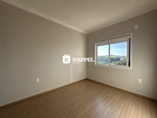 Uma sala de estar com piso de madeira e uma grande janela com vista para a paisagem.