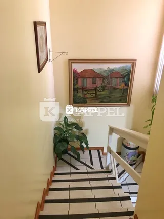 Foto de um corredor com escadaria em um imóvel.