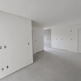 Vista de um corredor interno com paredes brancas.