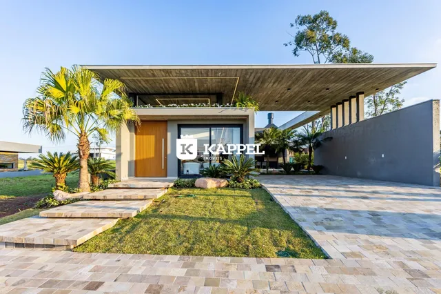 Vista externa de uma casa moderna em Lajeado, com paisagismo e área externa pavimentada.