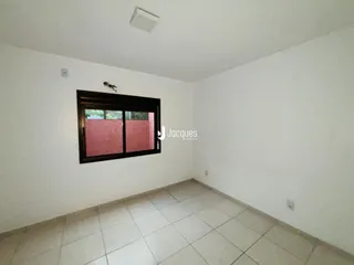 Interior de um cômodo com piso de cerâmica e janela.