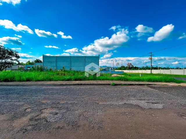 Vista externa de uma propriedade com vegetação verde e céu azul.