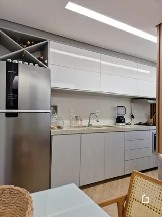 Cozinha moderna com armários brancos e eletrodomésticos de aço inoxidável.