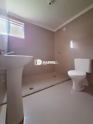 Foto de um banheiro interno mostrando uma pia e um vaso sanitário.