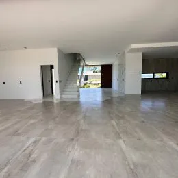 Vista de um hall amplo com escadaria em um imóvel.
