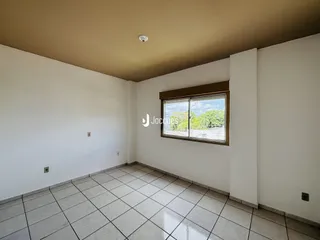 Ambiente interno de uma sala com piso de cerâmica clara e janela.