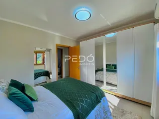 Quarto com armários brancos e cama de casal.