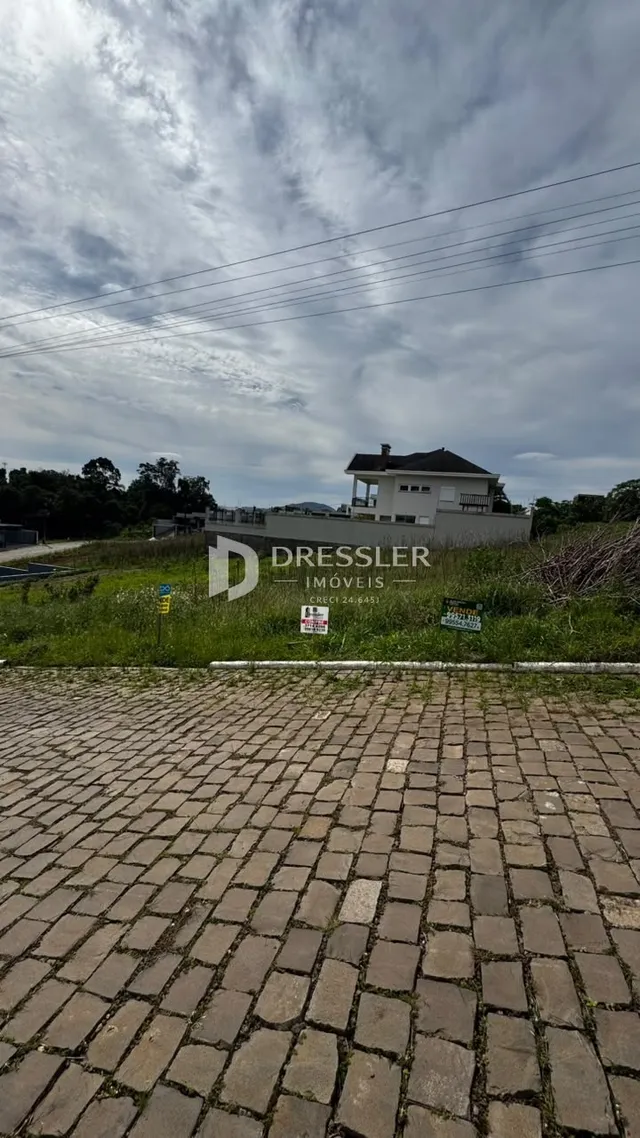Vista da fachada de uma residência em Lajeado, Brasil, com área pavimentada na frente.