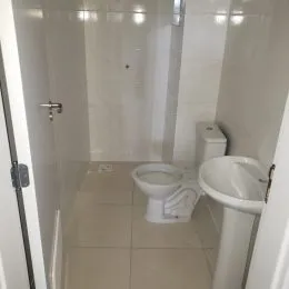 Foto de um banheiro interno com revestimento de azulejos brancos.