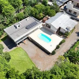 Vista aérea de uma propriedade com piscina e jardim em Lajeado.