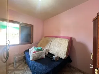 Quarto com cama e janela em uma residência.