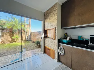 Vista da cozinha com porta de vidro que se abre para o jardim.