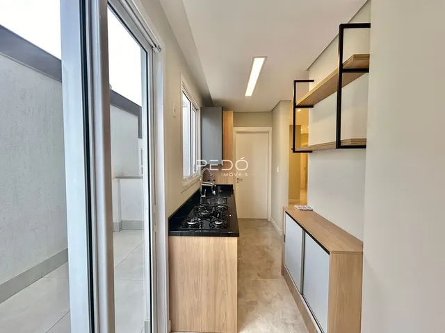 Vista de um corredor com bancada de cozinha em um imóvel no Brasil.