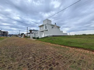 Fachada de uma casa branca em Lajeado, Brasil, sob um céu nublado.