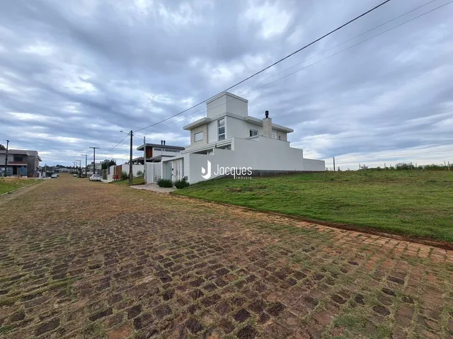 Fachada de uma casa branca em Lajeado, Brasil, sob um céu nublado.