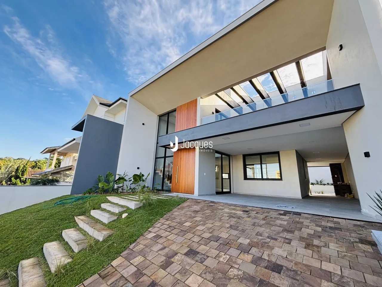 Fachada moderna de uma residência em Lajeado, Brasil, com jardim e terraço.
