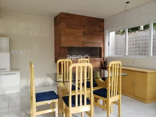 Uma sala de jantar com parede de destaque de madeira e mesa de jantar.