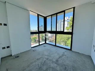 Ambiente interno com grandes janelas de vidro que oferecem uma vista da paisagem.