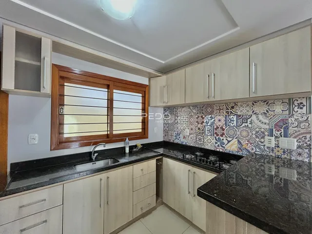 Foto de uma cozinha com armários e bancada escura.