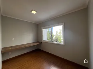 Uma sala de estar com piso de madeira e janela.