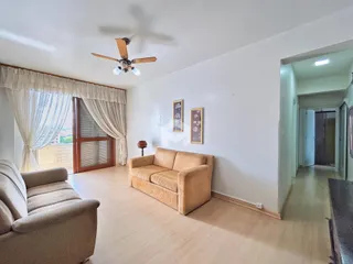 Sala de estar com sofá e piso de madeira clara.