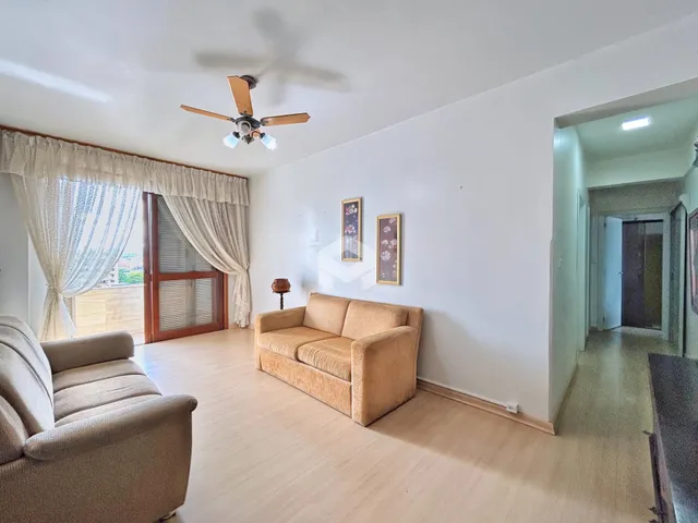 Sala de estar com sofá e piso de madeira clara.
