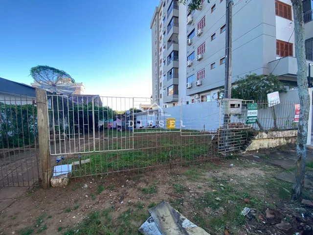 Vista externa da propriedade com cerca de metal e área gramada na frente.