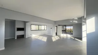 Uma sala ampla e iluminada com vista para a paisagem externa.