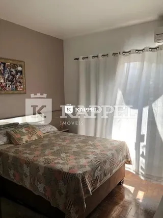 Quarto com cama e cortinas brancas.