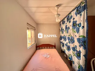 Quarto com cama rosa e cortina floral azul e branca.