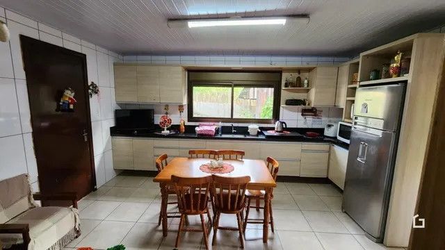 Foto da sala de jantar e cozinha de uma residência.