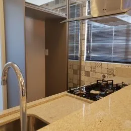 Foto de um balcão de cozinha com revestimento de azulejos e bancada clara.