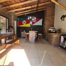 Ambiente interno com teto de madeira aparente e paredes de tijolo aparente.