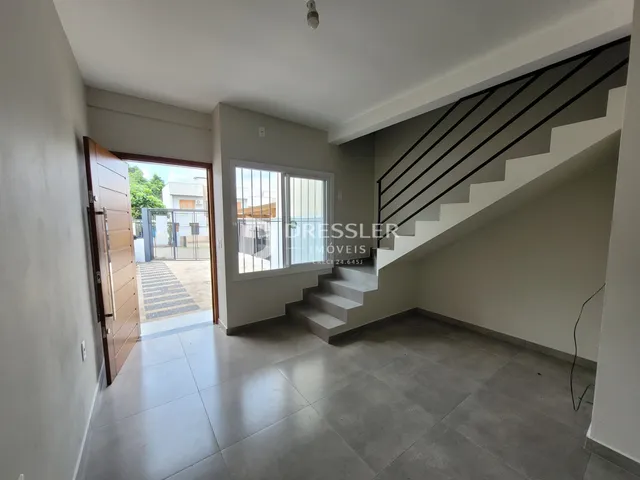 Hall de entrada com escadaria e piso de cerâmica em imóvel no Brasil.