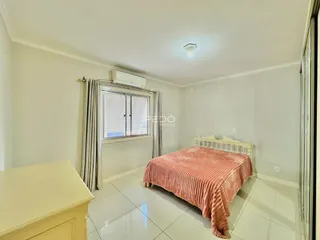 Quarto com cama e janela em um ambiente claro.