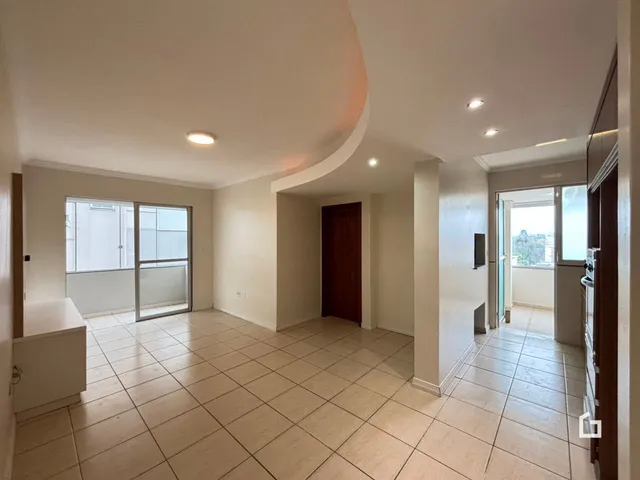 Sala de estar com piso de cerâmica clara e paredes brancas.