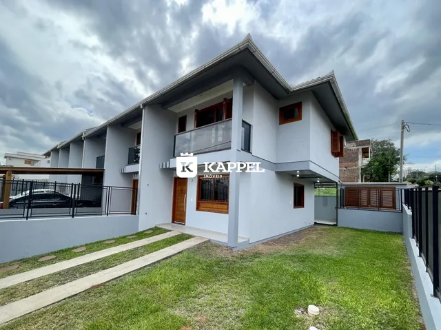 Fachada de uma casa residencial em Lajeado, Brasil, com jardim frontal e varanda no andar superior.