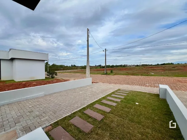 Vista da área externa da propriedade com piso e gramado.