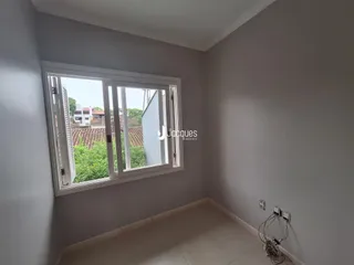 Vista interna de um cômodo com janela em uma residência.