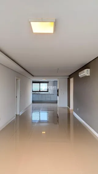Corredor interno de uma residência com piso de cerâmica claro.