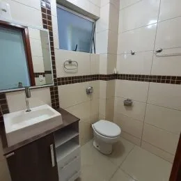 Foto de um banheiro com revestimento de azulejos brancos.