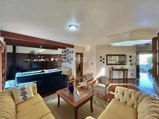 Sala de estar com piso de madeira e sofá azul.